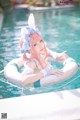 A woman in a bunny costume floating in a pool.