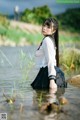 A woman in a school uniform is standing in the water.