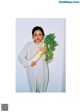 A woman holding a bunch of celery in her hands.