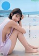 A woman sitting on a beach next to the ocean.